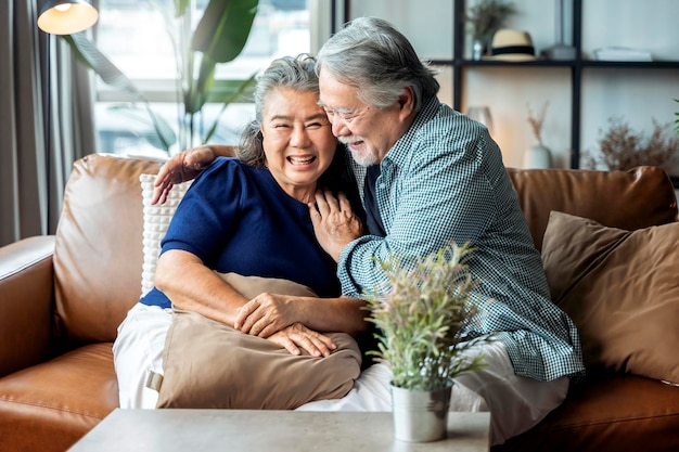 Free photo old senior asian retired couple enjoy talking conversation together on sofa with happiness laugh smile and joyful at homeasian old mature adult stay home quarantine period concept