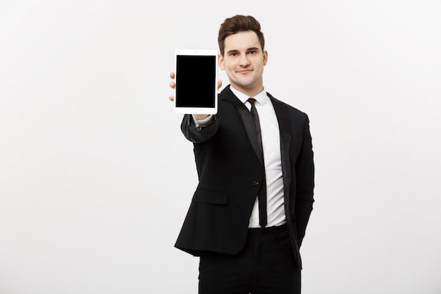 Free photo business concept: smiling handsome businessman presenting website or presentation on tablet.