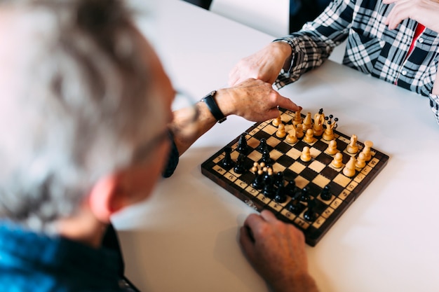Free photo elderly couple in retirement home playing chess