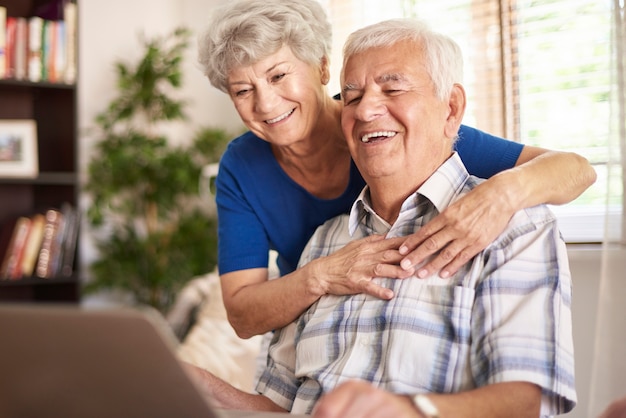 Free photo happy grandparents using their digital laptop