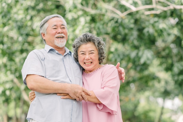 Photo happy senior couple holding each other in park